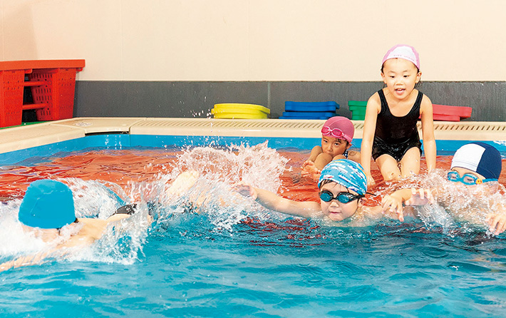 温水プール・体育館など充実の施設で<br />実践的な英語力、運動、知能を育む