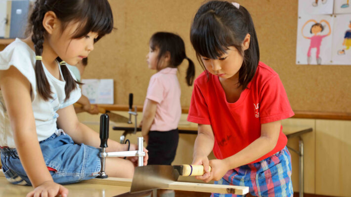 川崎市麻生区にある風の谷幼稚園。のこぎりを使う子どもたち。