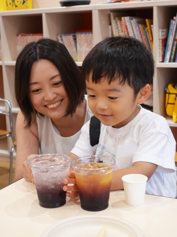 食育キャラバンでカラフルジュースをお母さんに作って上げている園児の様子