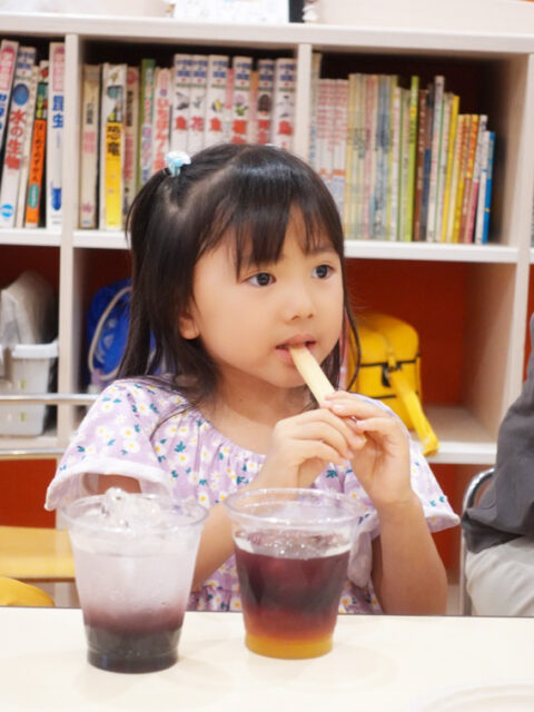 食育キャラバンで砂糖の原料であるサトウキビをかじる子どもの様子